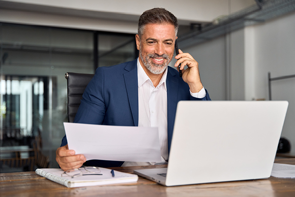 Man on cellphone in front of laptop