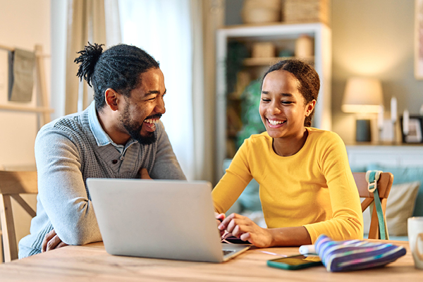 Father and daughter budgeting at table