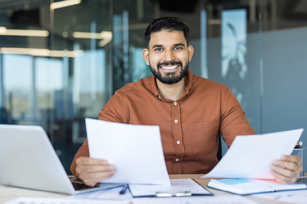 Happy man smiling with paperwork in hand