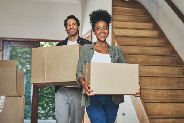 Couple in new home holding boxes