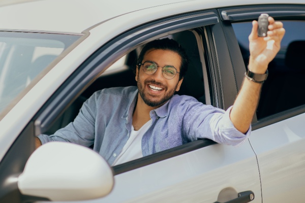 Man holding car keys outside of car window