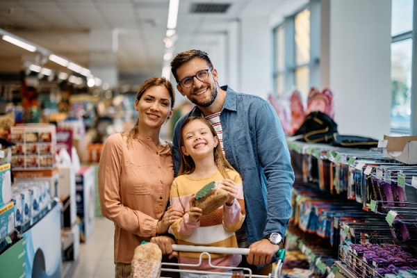 Family shopping in store, looking at camera and smiling 