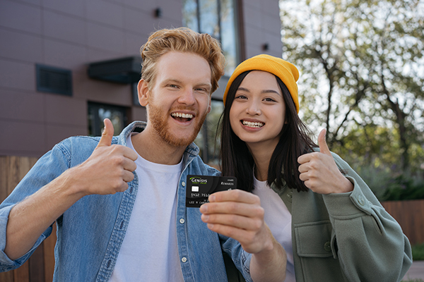 Friends smiling in camera with a credit card