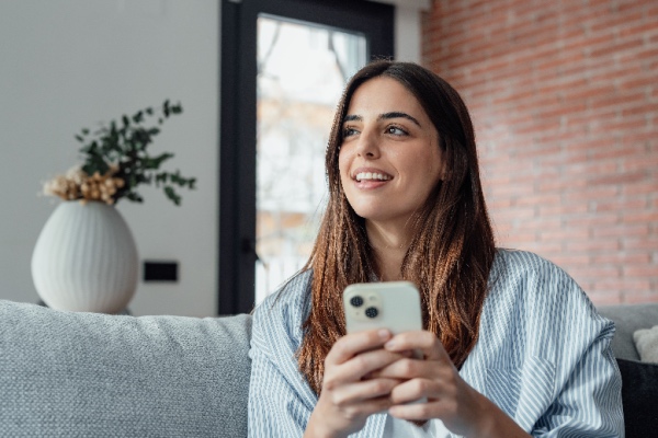 Young girl sitting at home on cell phone