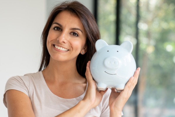 Woman holding piggy bank near her face