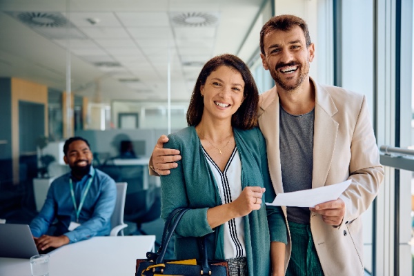 Couple smiling with paperwork in hand