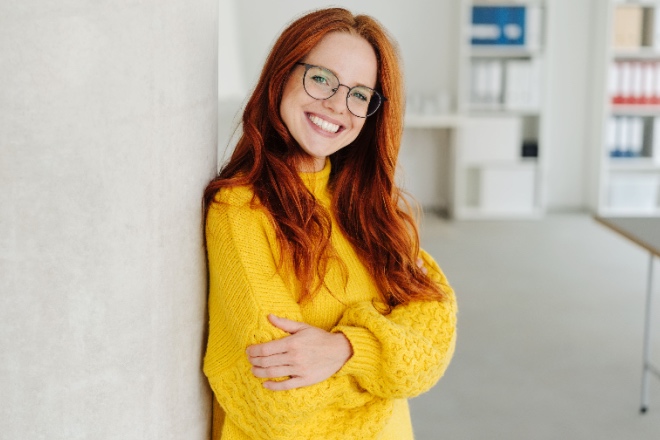 Woman smiling wearing a sweater 