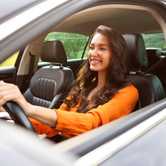 woman smiling while driving car