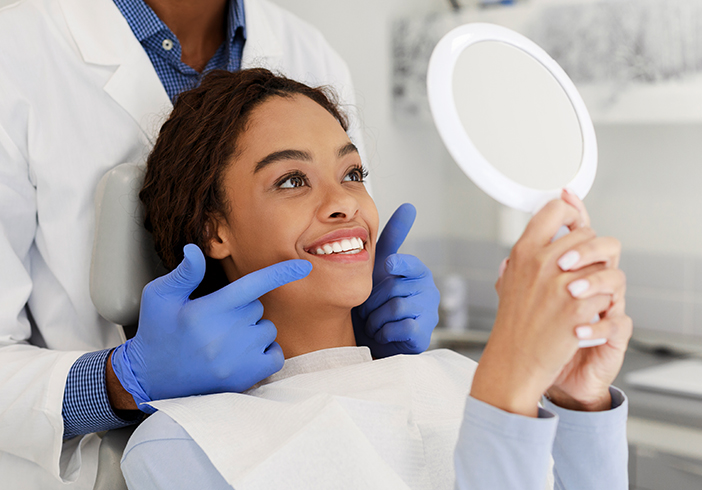Woman sitting in dentist's chair looking in a mirror